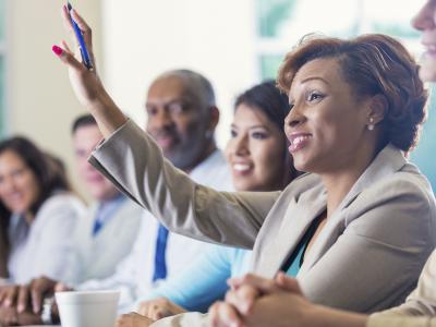 Woman raising hand in meeting